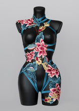 Load image into Gallery viewer, Pretty Prussian blue lace lingerie bodycage with embroidered lace pink lotus flowers and gold fish in an asymmetric design which wraps around the body giving the impression of natural movement. The lace has soft and stretchy elasticated straps and the design follows down the left thigh with garter straps holding in place: 
